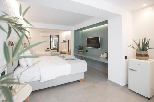 a bedroom with a white bed and a bathroom at San Panteleimon in Paralia Panteleimonos