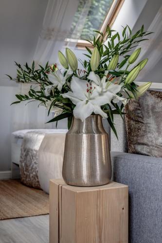 a vase filled with white flowers sitting on a table at Wellness apartmány Český ráj & Biokolna in Lomnice nad Popelkou