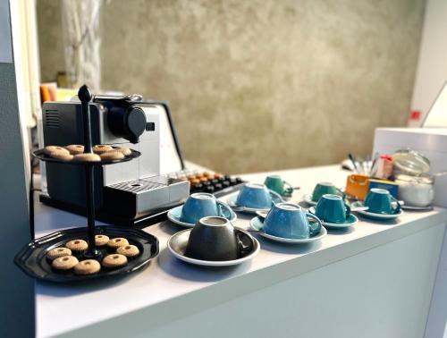 a counter with cups and saucers and a coffee maker at Butik Art Hotel in Budapest