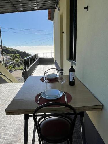 een houten tafel met een glas wijn erop bij Fernanda's House in Ribeira Brava