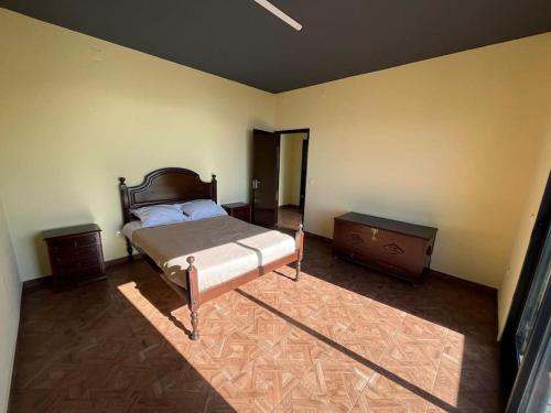 een slaapkamer met een bed, een dressoir en een tafel bij Fernanda's House in Ribeira Brava