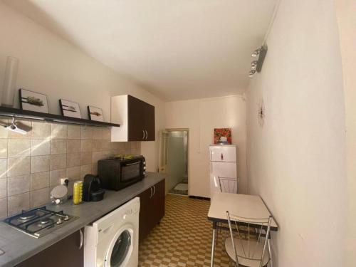 une petite cuisine avec une cuisinière et un micro-ondes dans l'établissement Charmant T2 coeur de ville, à Ajaccio