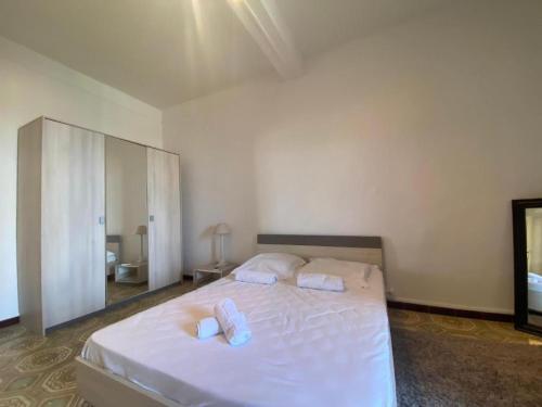 une chambre avec un grand lit blanc avec deux serviettes dans l'établissement Charmant T2 coeur de ville, à Ajaccio