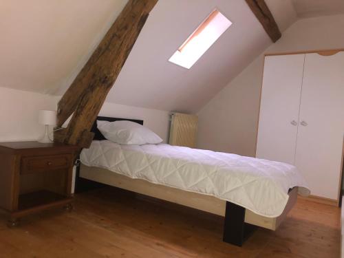 une chambre avec un lit et une lucarne dans l'établissement Entre champs et forêt, à Allouis