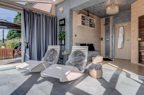 a living room with two chairs and a couch at Wellness apartmány Český ráj & Biokolna in Lomnice nad Popelkou