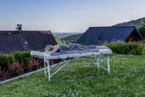 a woman laying on a bed in the grass at Wellness apartmány Český ráj & Biokolna in Lomnice nad Popelkou