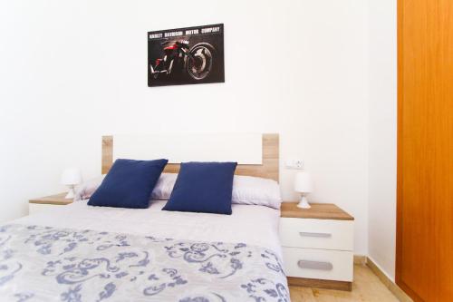 ラ・ピネーダにあるAQUAMARINA C HomeStay By Turismarのベッドルーム(青い枕のベッド1台付)