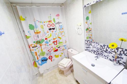 baño con cortina de ducha con dibujos. en AQUAMARINA C HomeStay By Turismar, en La Pineda