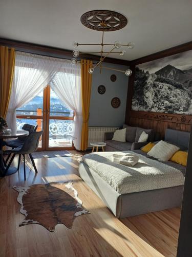 a bedroom with a bed and a living room at Apartament Góralski in Bukowina Tatrzańska