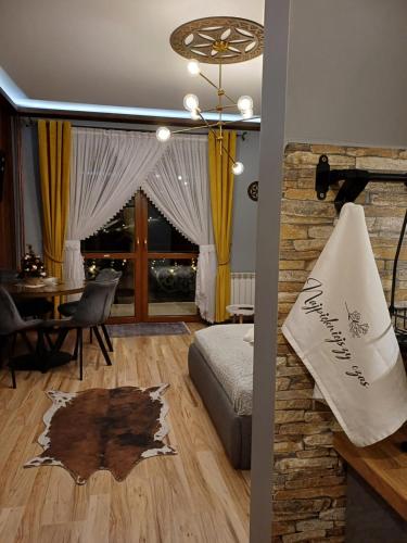 a living room with a bed and a dining room table at Apartament Góralski in Bukowina Tatrzańska