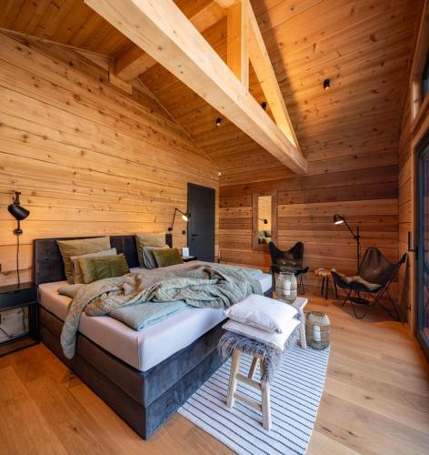 a bedroom with a large bed in a wooden room at Roubenka Smetanka in Smetanova Lhota