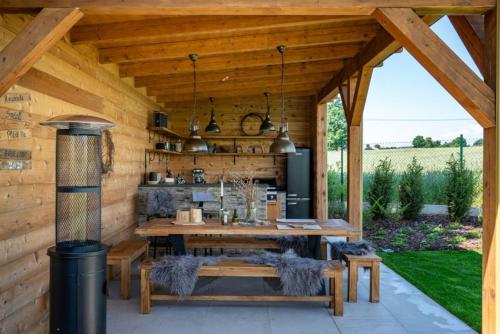 a wooden pavilion with a table and a stove at Roubenka Smetanka in Smetanova Lhota