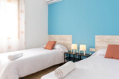 twee bedden naast elkaar in een slaapkamer bij Chalet Campomar Beach Málaga in Torre de Benagalbón