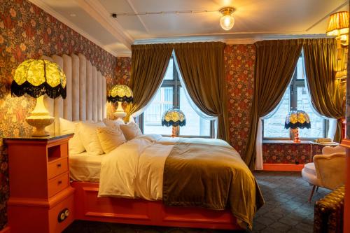 a bedroom with a large bed and windows at Charmante - Skostredet Hôtel in Bergen