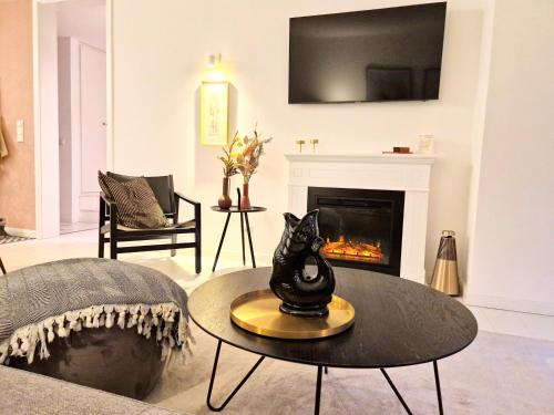 a living room with a fireplace and a cat statue on a table at Ferienwohnung Lieblingssuite am Strand in Ahlbeck