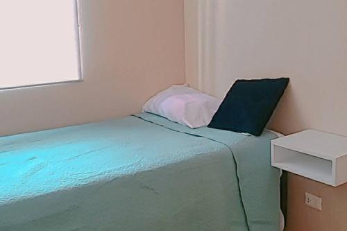 a small bedroom with a bed with a laptop on it at Departamento Piura in Piura