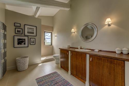 une salle de bain avec un lavabo et un miroir dans l'établissement Mas De Champclos, à Saint-Privat-de-Champclos