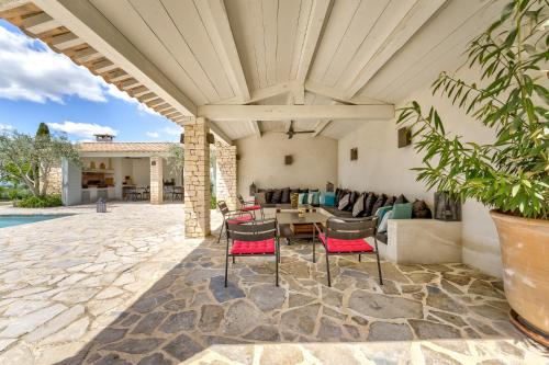 un patio extérieur avec une table et des chaises dans l'établissement Mas De Champclos, à Saint-Privat-de-Champclos