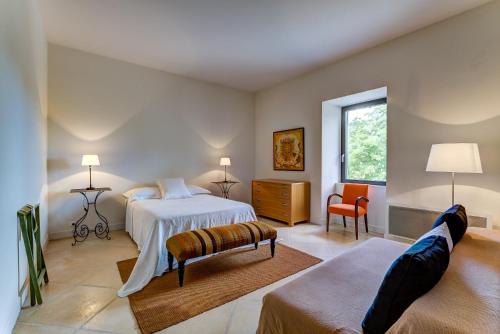 une chambre avec un lit, un canapé et une fenêtre dans l'établissement Mas De Champclos, à Saint-Privat-de-Champclos