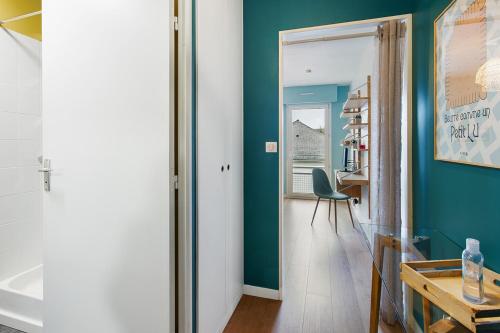 Cette chambre est dotée d'un mur vert et d'une table en bois. dans l'établissement Joli studio - Parking Privé - WIFI Très Haut Débit - Au calme, à Nantes