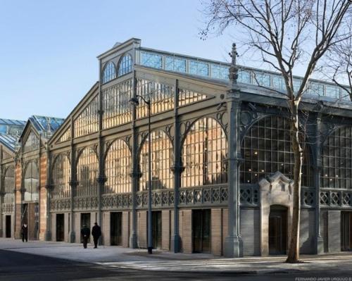 un grand bâtiment avec des gens qui marchent devant dans l'établissement Charmant duplex historique Cœur Marais, à Paris
