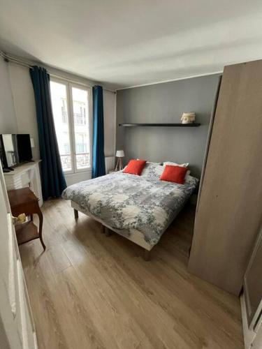 a bedroom with a bed with red pillows on it at Nice flat Paris 16 near to Eiffel Tower in Paris