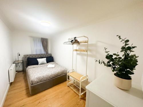 a bedroom with a bed and a potted plant at Flat 4, Stay in Aldgate in London