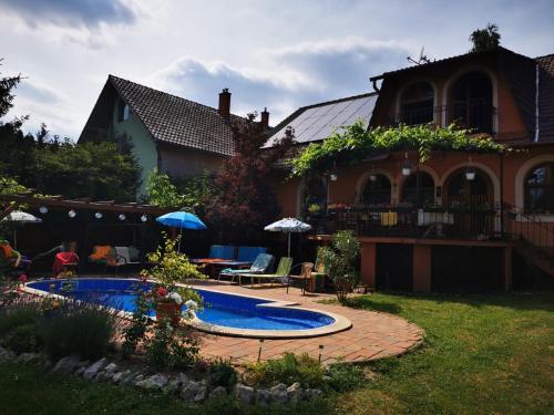 a house with a swimming pool in front of a yard at Katica Vendégház Somogyvár - Ladybird Villa Somogyvár in Somogyvár