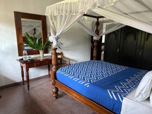 1 dormitorio con cama con dosel y mesa en Hotel 106, en Colombo