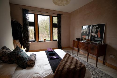 a bedroom with a large bed and a window at Crow Nest House in Hebden Bridge