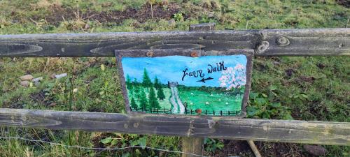 a sign on the side of a wooden fence at The Old House at Belfield in Tralee