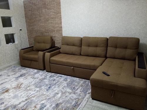 sala de estar con sofá y 2 sillas en 3 комнатная квартира, en Uralsk