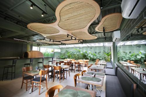 um restaurante com mesas, cadeiras e plantas em Transamerica Executive Nova Paulista em São Paulo