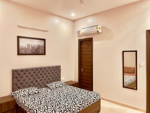 een slaapkamer met een bed met een zwart-wit dekbed bij Woodstock Villa Homestay Ranjit Avenue in Amritsar