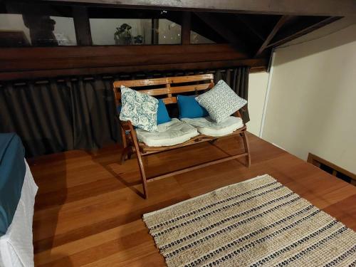 a room with a chair with pillows and a rug at Brisas do Sambaqui in Florianópolis