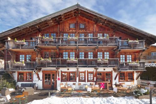 a large wooden house with a balcony on it at La Ferme du Golf in Megève