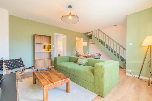 un salon avec un canapé vert et une table dans l'établissement 3 bedroom house with garden near Lille + garage, à Lambersart
