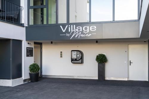 een gebouw met een bord dat het dorp van de spiegel leest bij Village by Maier - kontaktloser Check-in in Hohenems