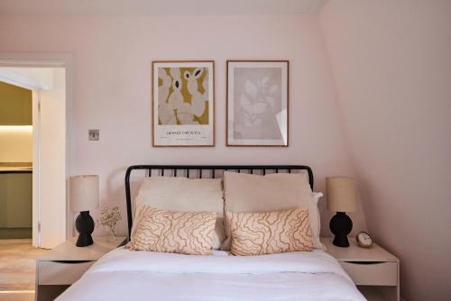 a bedroom with a bed with two lamps and two pictures on the wall at The North Notting Hill Crib - Bright 1BDR Flat in London