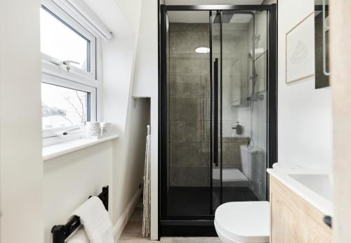 a bathroom with a shower and a toilet and a sink at The North Notting Hill Crib - Bright 1BDR Flat in London