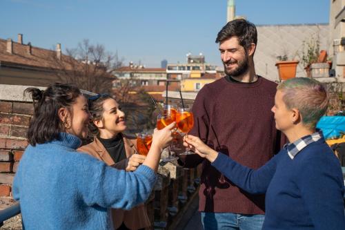 a group of people holding up drinks at Babila Hostel & Bistrot in Milan