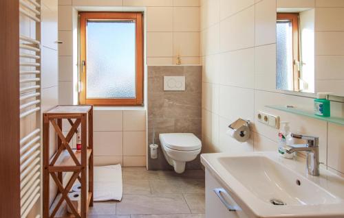 Baño blanco con aseo y lavamanos en 4 Bedroom Stunning Home In Uderns en Uderns