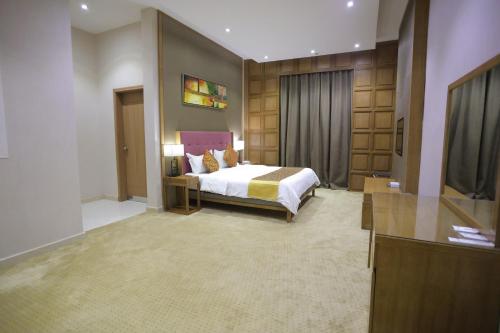 a hotel room with a bed and a television at Dar Hashim Al Nuzha Serviced Apartments - Economic in Riyadh