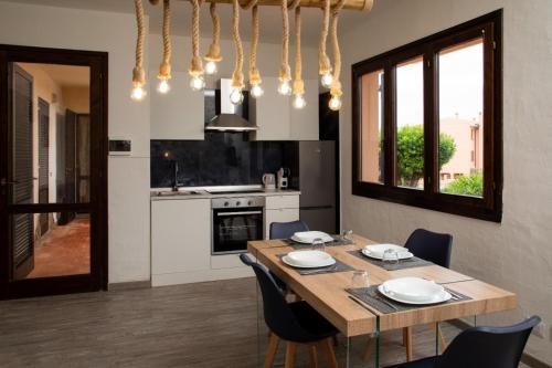 a dining room with a table and a kitchen at Casa Mediterraneo Santa Teresa di Gallura in Porto Pozzo