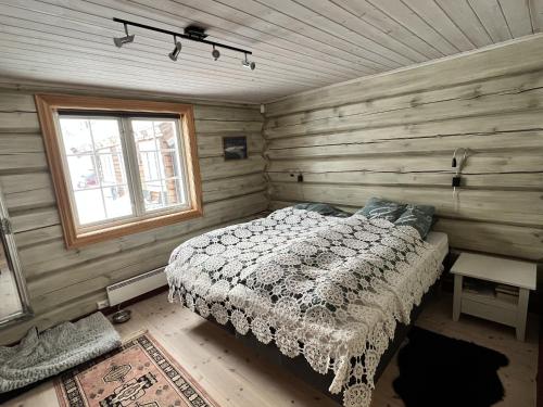 ein Schlafzimmer mit einem Bett in einem Holzzimmer in der Unterkunft Sletthovdun 151 in Ål