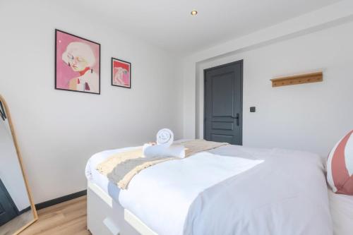 a bedroom with a white bed with a clock on it at House 4bed 2bath with garden and private parking. in La Madeleine