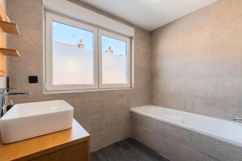 a bathroom with a tub and a sink and a window at House 4bed 2bath with garden and private parking. in La Madeleine