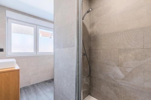 a bathroom with a shower with a glass door at House 4bed 2bath with garden and private parking. in La Madeleine