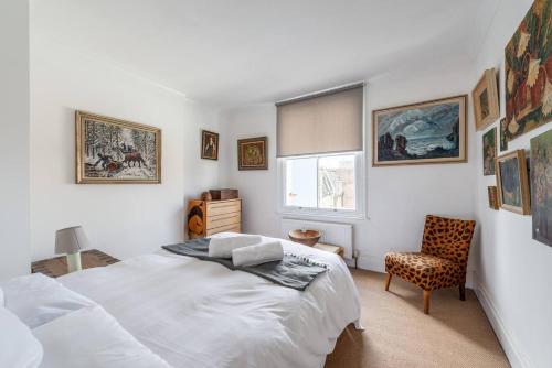 a bedroom with a bed and a chair at Chic Top Floor Apartment in the heart of Notting Hill Ladbroke Grove in London