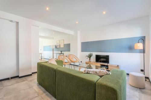 a living room with a green couch and a table at House 4bed 2bath with garden and private parking. in La Madeleine